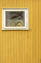 Obraz na płótnie Canvas Bretterwand / Bretterwand eines Gartenhäuschens mit Fenster