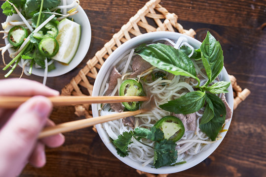 vietnamese pho with beef being eaten with chopsticks