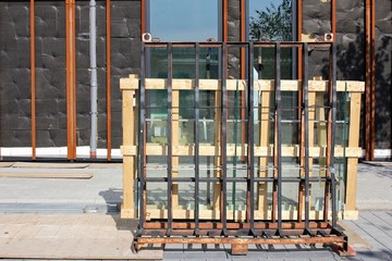 Palette mit Fensterglas vor einem Neubau