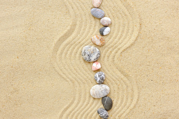 Fototapeta na wymiar Striped stones on the sand,can be used as background
