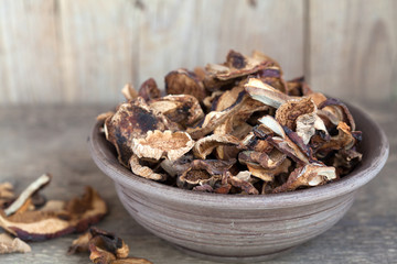 Mixed dried mushrooms (Porcini) in a bowl on the wooden table