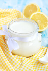 Obraz na płótnie Canvas Homemade yogurt in small glass jar on a blue table
