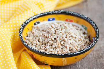 Green buckwheat sprouts in a yellow bowl, close up