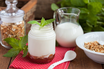 Obraz na płótnie Canvas Breakfast: homemade granola in a white plate and yogurt with jam