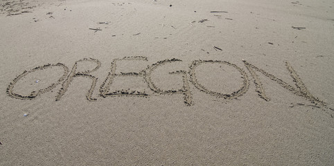 Oregon word written in sand beach