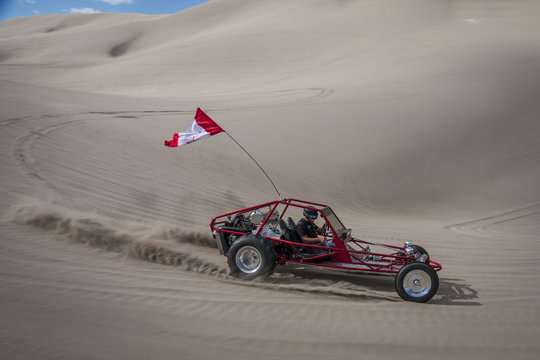 Red Sand Dune Buggy Racing By In The Sand Dunes