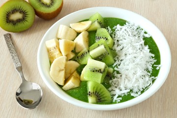 Green smoothie bowl with bananas, fresh kiwi and coconut