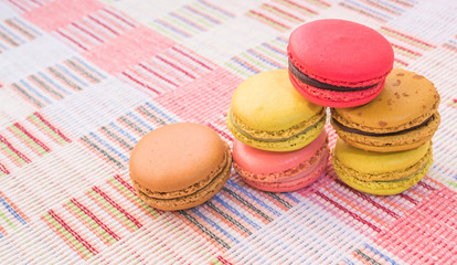 Sweet and colourful french macaroons on cotton cloth background.