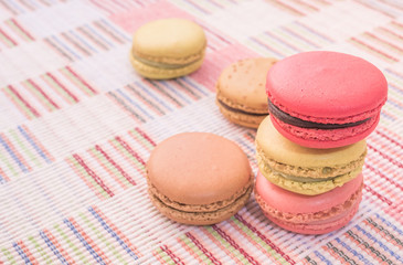 Sweet and colourful french macaroons on cotton cloth background.