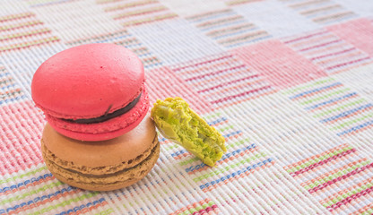 Sweet and colourful french macaroons on cotton cloth background.
