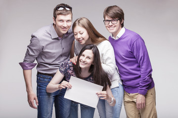 Obraz premium Group of young friends with advert board