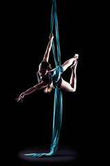 Young woman gymnast with blue gymnastic aerial silks
