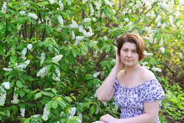  adult woman near blossoming bird cherry in the park