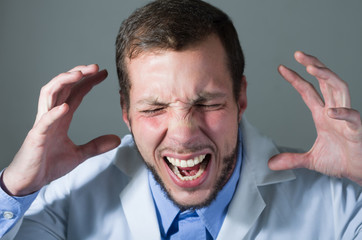Closeup portrait of handsome young angry desperate doctor