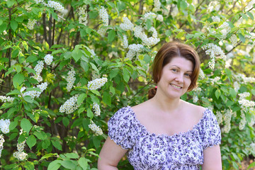  adult woman near blossoming bird cherry in the park