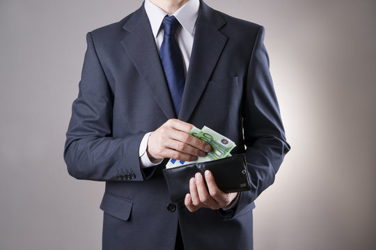 Businessman with money in purse in hands