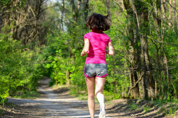 Naklejka na ściany i meble Woman runner jogging outdoors in forest, exercising, sport 