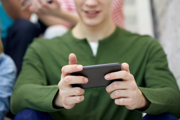 close up of young man with smartphone