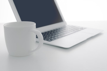 Fototapeta premium Cappuccino cup on laptop. Isolated on white background