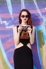 Beautiful redhead women with retro camera