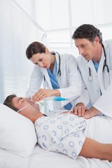 Obraz premium Worried doctors doing heart massage and holding oxygen mask