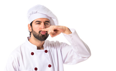 Chef doing moustache gesture over shite background