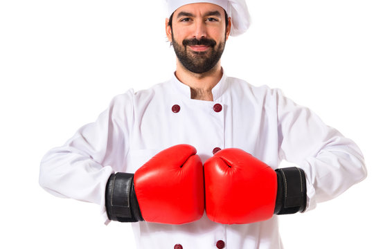 Chef with boxing gloves over white background