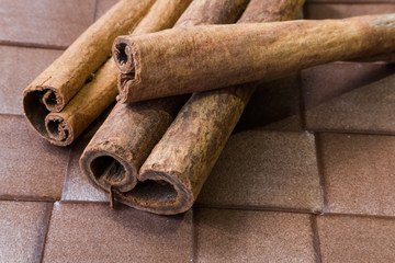 Cinnamon sticks close-up on brown background