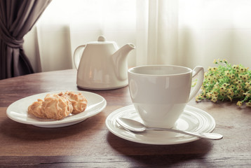 Cup of tea with teapot and cookies on table, vintage style