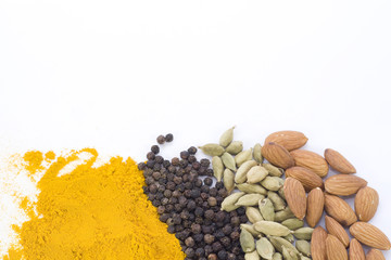 Turmeric, Peppercorn, Cardamon, and Almonds isolated on a white background with room for copy