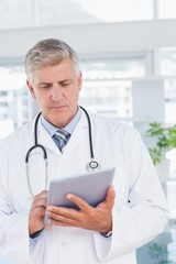 Smiling doctor holding tablet