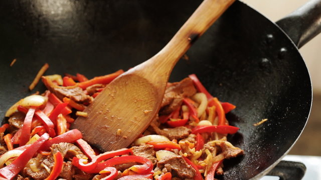 Wok cooking - chef preparing beef with vegetables