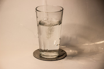 Wasser wird in ein Glas eingeschenkt