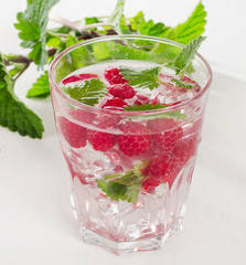 Cold drink with raspberries, ice and fresh mint.