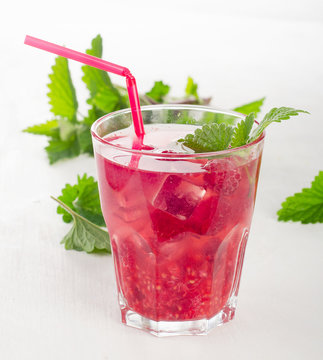 Summer cold drink with raspberries, ice and mint leaves.