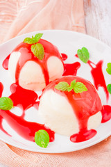 Panna Cotta with raspberry sauce on wooden table