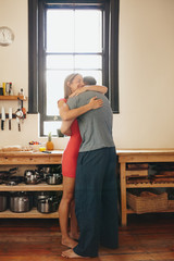 Young couple embracing each other in kitchen