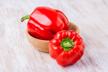 Two red peppers on wooden table