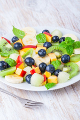 Fresh fruit salad with kiwi, berries, banana and fresh mint