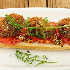 Lentil patty sandwich with tomato, sesame seeds and carrot green