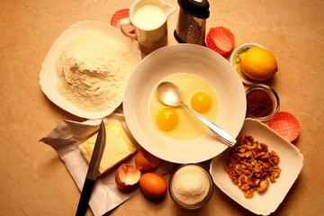 Broken eggs in a dish and the ingredients for the recipe.