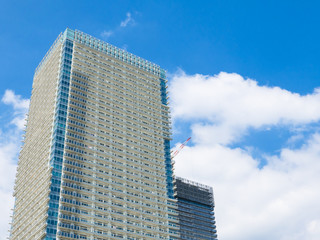 Obraz premium building and cranes under construction against blue sky
