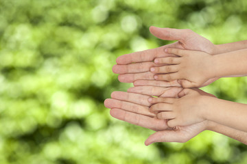 father and son holding hands on natural background