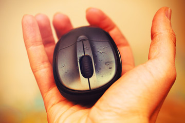 Open Hand and computer mouse  with water drops. Vintage picture