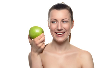 Lächelnde Frau schielt auf einen grünen Apfel in ihrer Hand