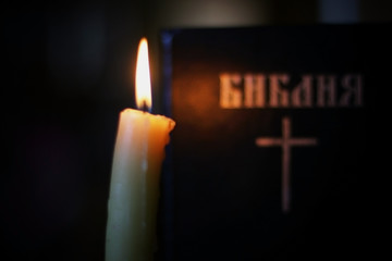 burning candle and bible religion