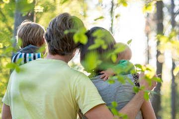 Young family enjoying a beautiful sunny day outdoors in a green