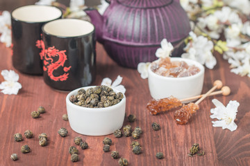 Obraz na płótnie Canvas Asian tea set with dried green tea and sugar