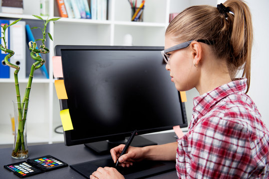 Woman graphic artist working with color palette and computer