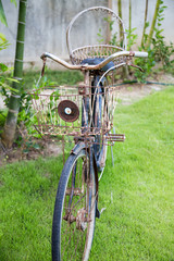 Part of antique rusty bicycle on green grass